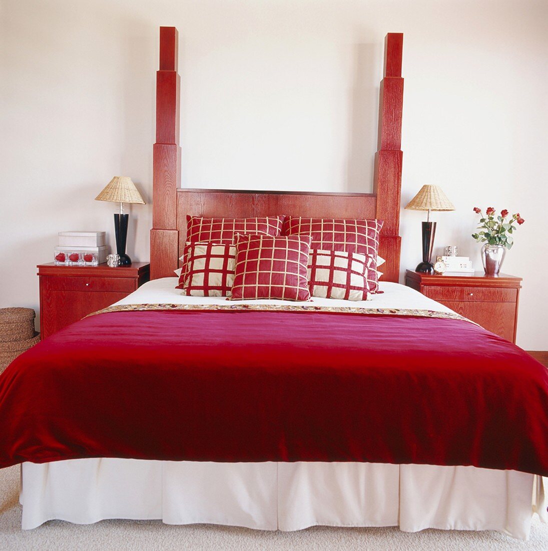 Rotes Doppelbett aus Holz mit auffälligem Kopfteil und zwei Nachttischen