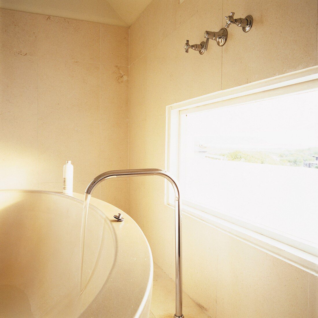 Detail einer Badezimmerecke aus Naturstein mit einem Langfenster