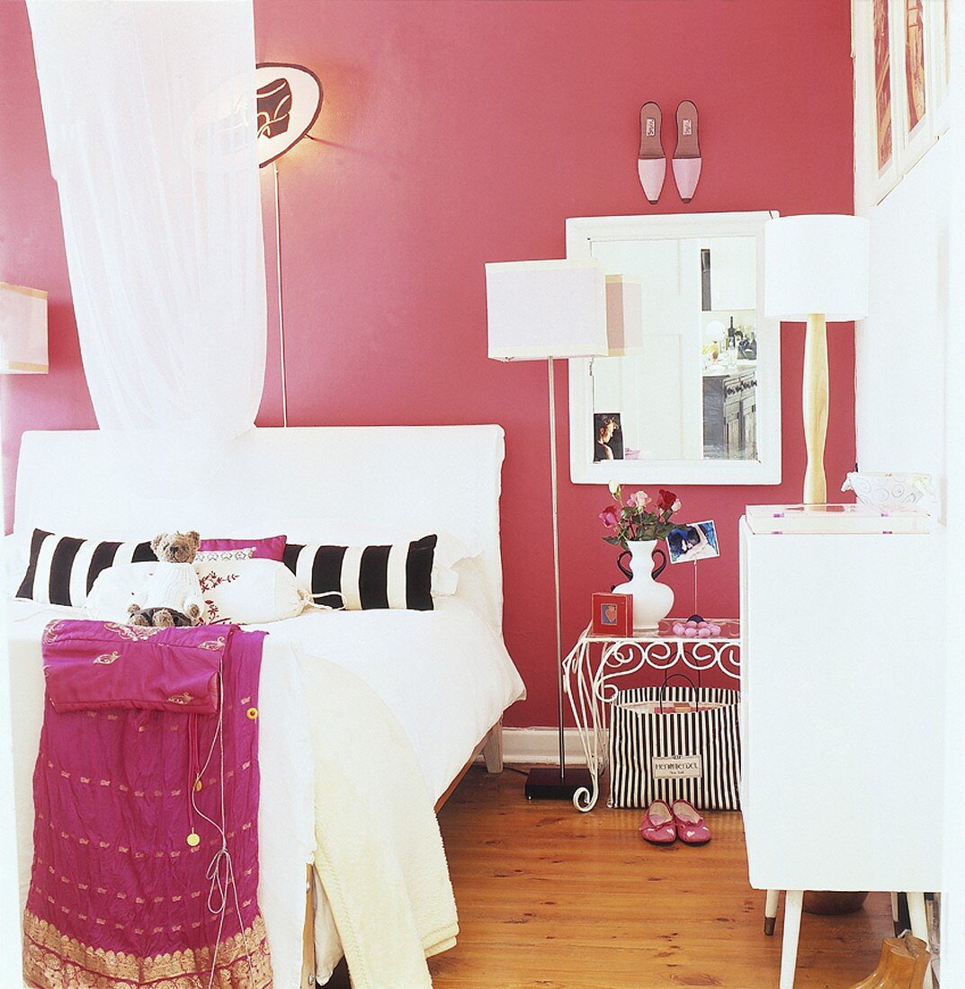 Farbenfrohes Schlafzimmer mit vielen Wohnaccessoires und Holzboden