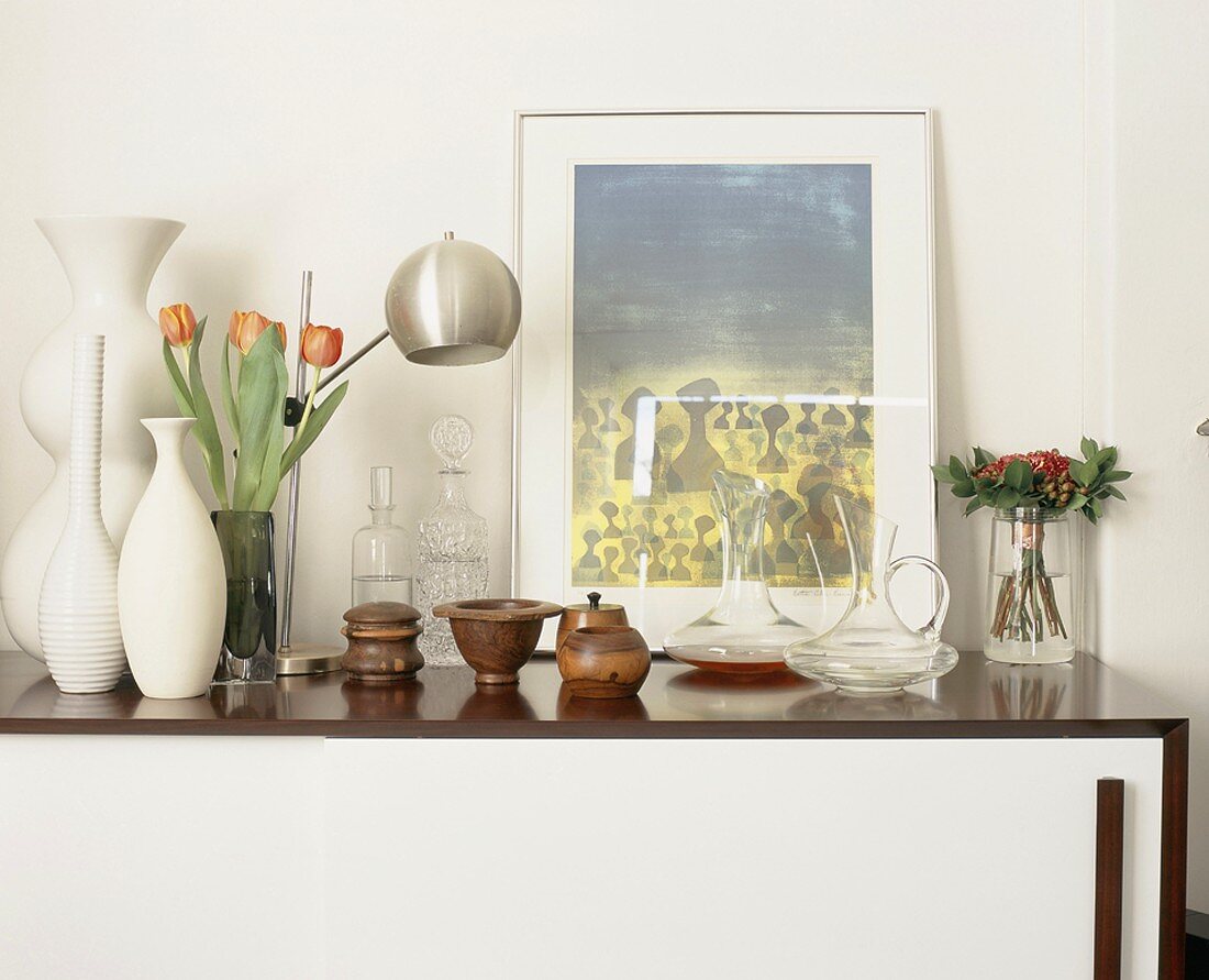 Vasen und Holzschalen auf einem modernen Sideboard