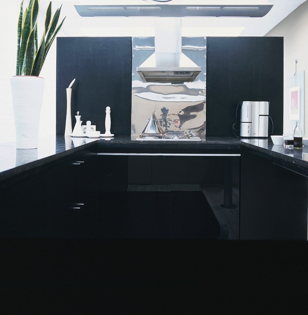 Moderne Küchenzeile in Schwarz mit Dunstabzug aus Edelstahl und Blechabdeckung