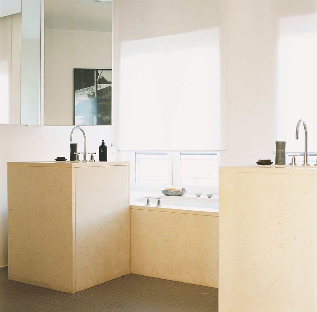 Badezimmer mit zwei separaten, rechteckigen Waschtischen, die eine Badewanne flankieren