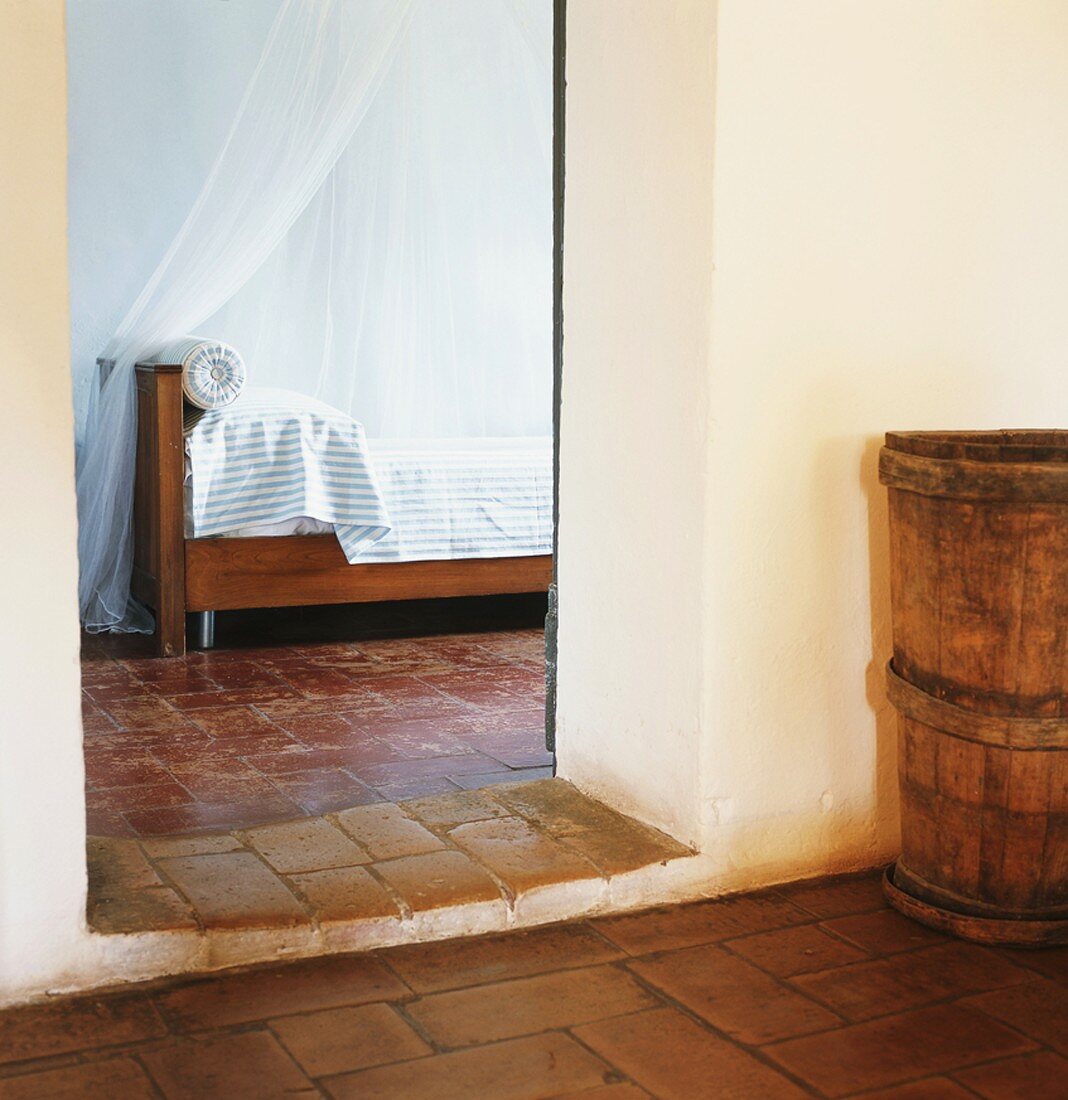 Blick ins Schlafzimmer eines rustikalen Wohnhauses mit altem Steinboden