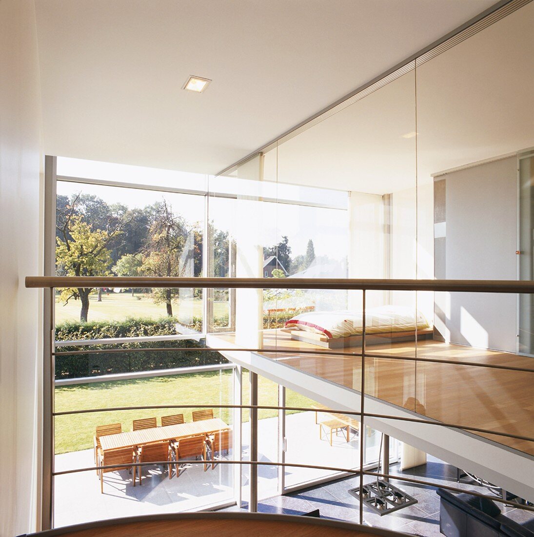 Blick auf Terrasse und Schlafraum eines hochmodernen Architektenhauses mit Glaswänden