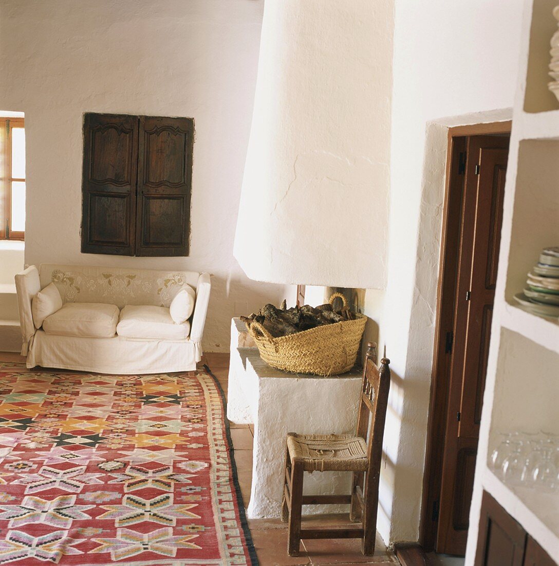 Wohnraum in einer traditionellen Finca mit Lehmkamin und einem schönen alten Knüpfteppich