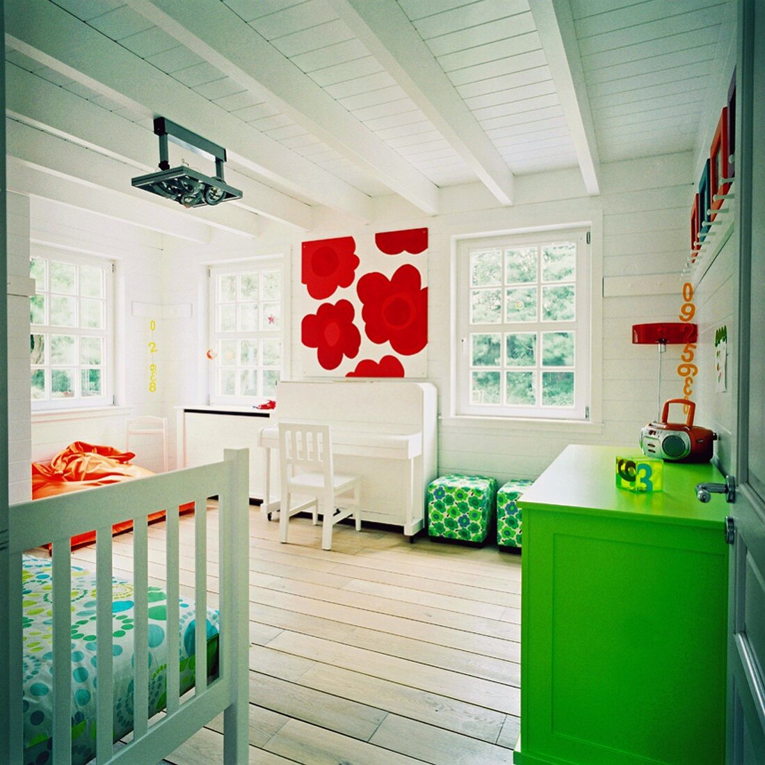 Ein Kinderzimmer mit weißem Klavier und bunten Wohnaccessoires