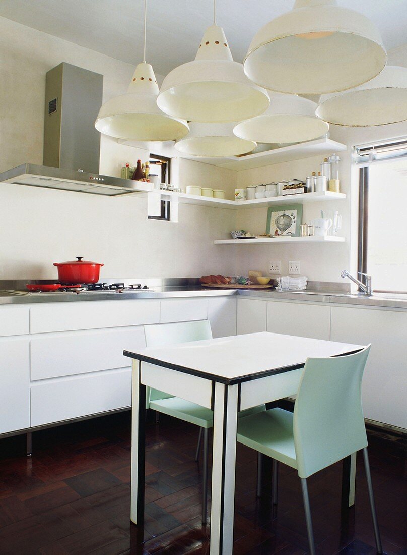Gleich sechs Hängelampen beleuchten den kleinen kleinen, schlichten Esstisch in der modernen Küche