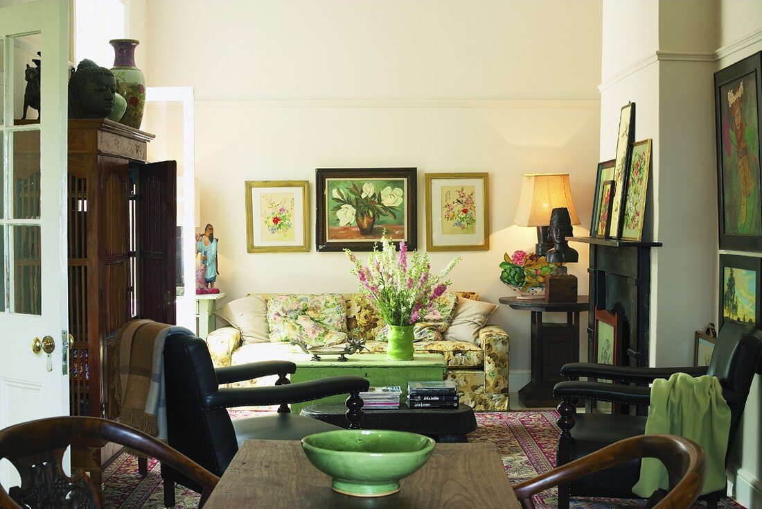 Antikmöbel und viele Gemälde verleihen diesem Wohnzimmer elegante Gemütlichkeit