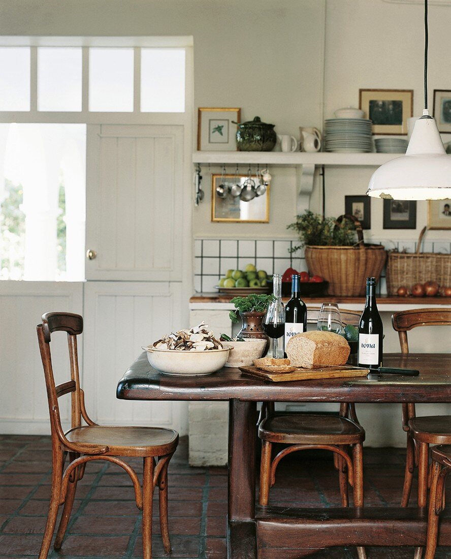 Rustikaler Esstisch und Bistrostühle in einem ehemaligen, zur Küche umgebauten Stall