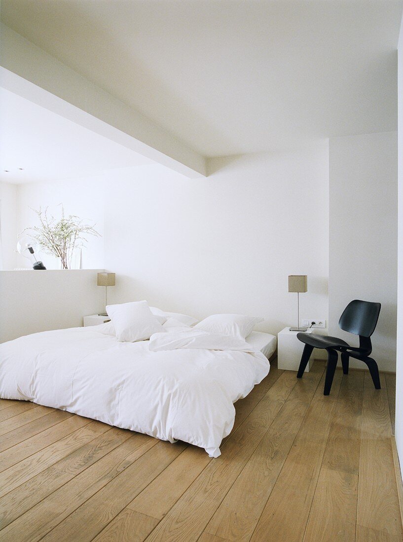 Puristisches Schlafzimmer in weiss mit schwarzem Eames Chair