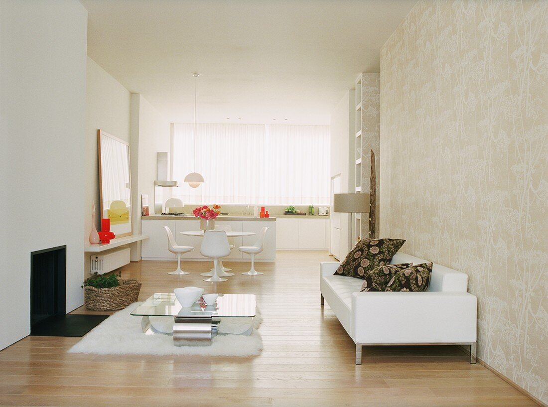 Ein puristischer Wohnraum mit Designersofa und Blick auf den offenen Koch- und Essbereich