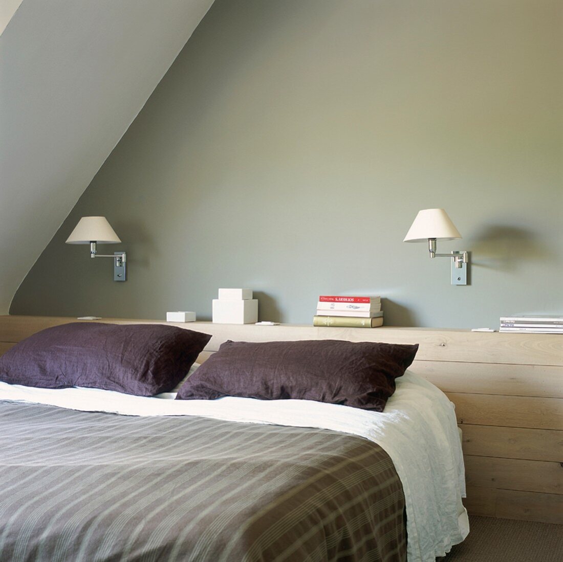 Ein holzvertäfelter Wandvorsprung dient am Kopfteil des Bettes als Ablagefläche
