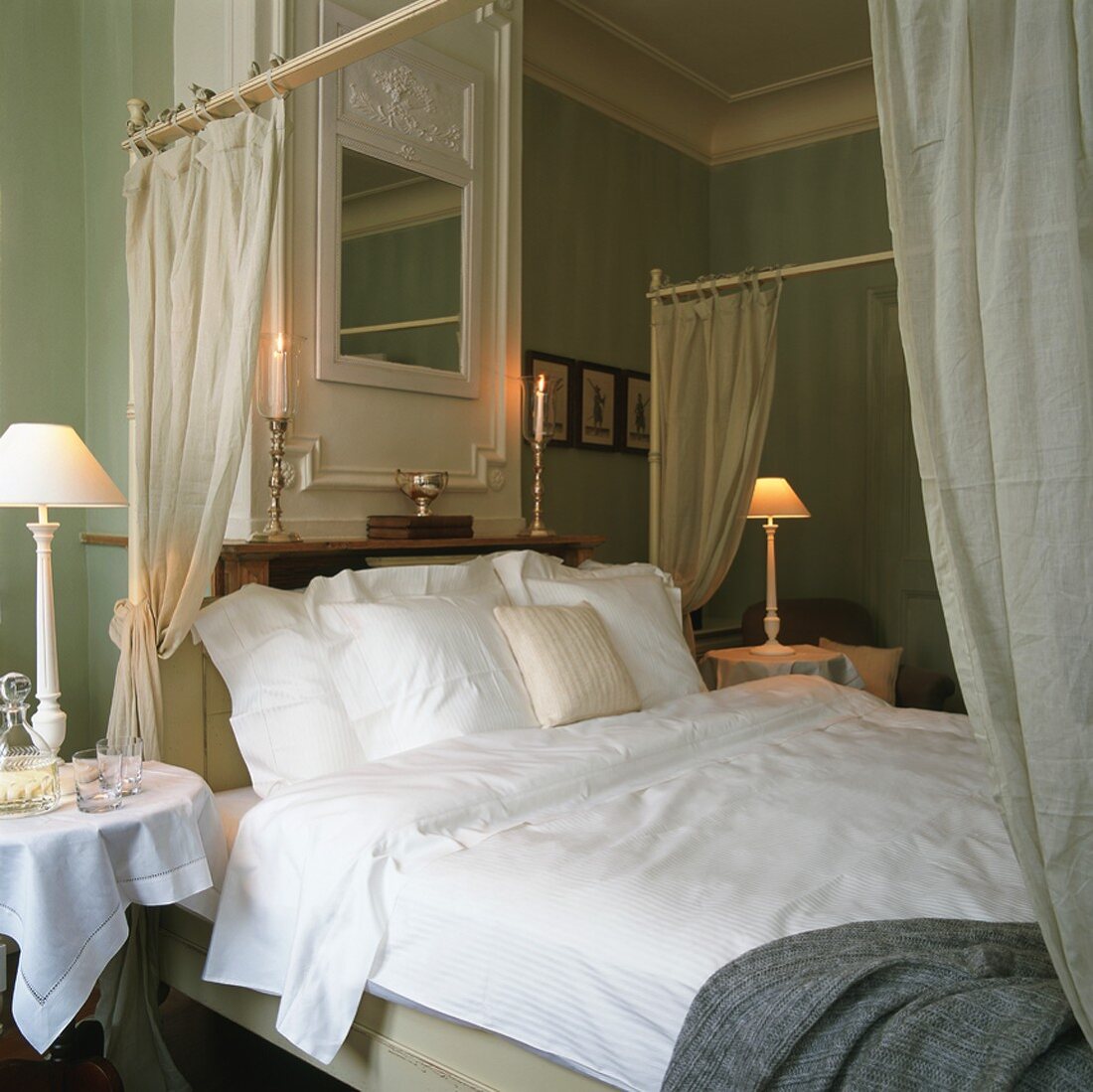 Ein gemachtes Himmelbett in einem klassisch-eleganten Schlafzimmer mit Stuckdecke