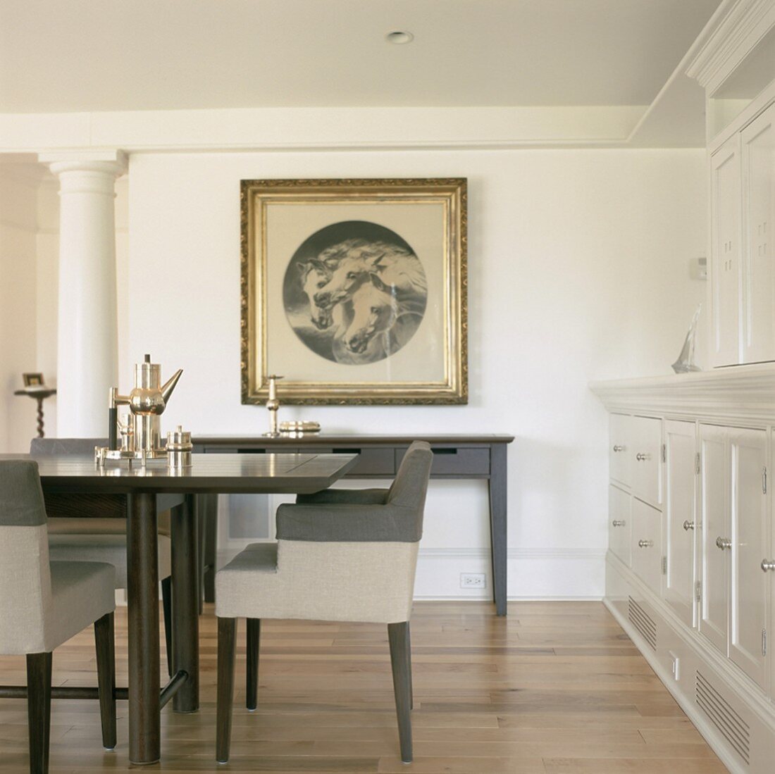 Moderne und zurückhaltende Esszimmermöblierung in klassischer Wohnarchitektur mit Dekosäule und Schrankwand