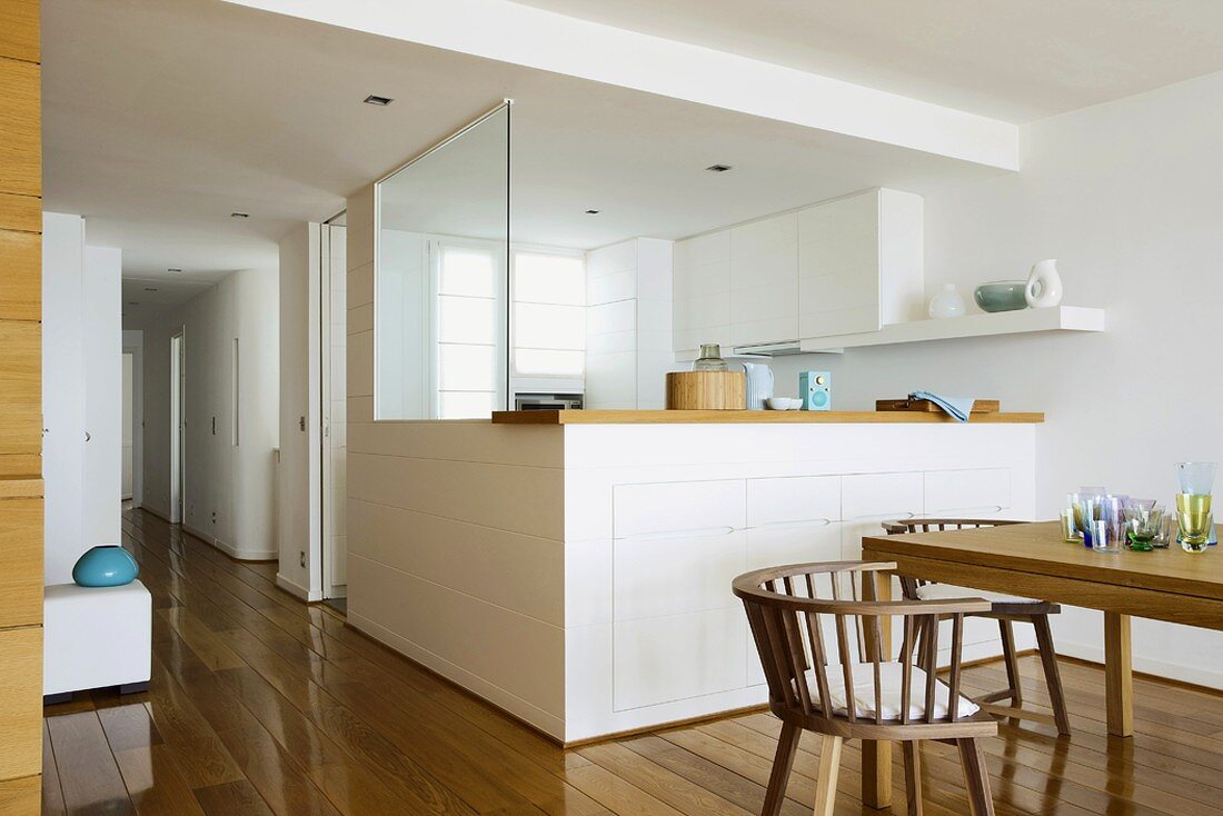 Moderne Esszimmergarnitur aus Holz mit Blick in die offene Küche
