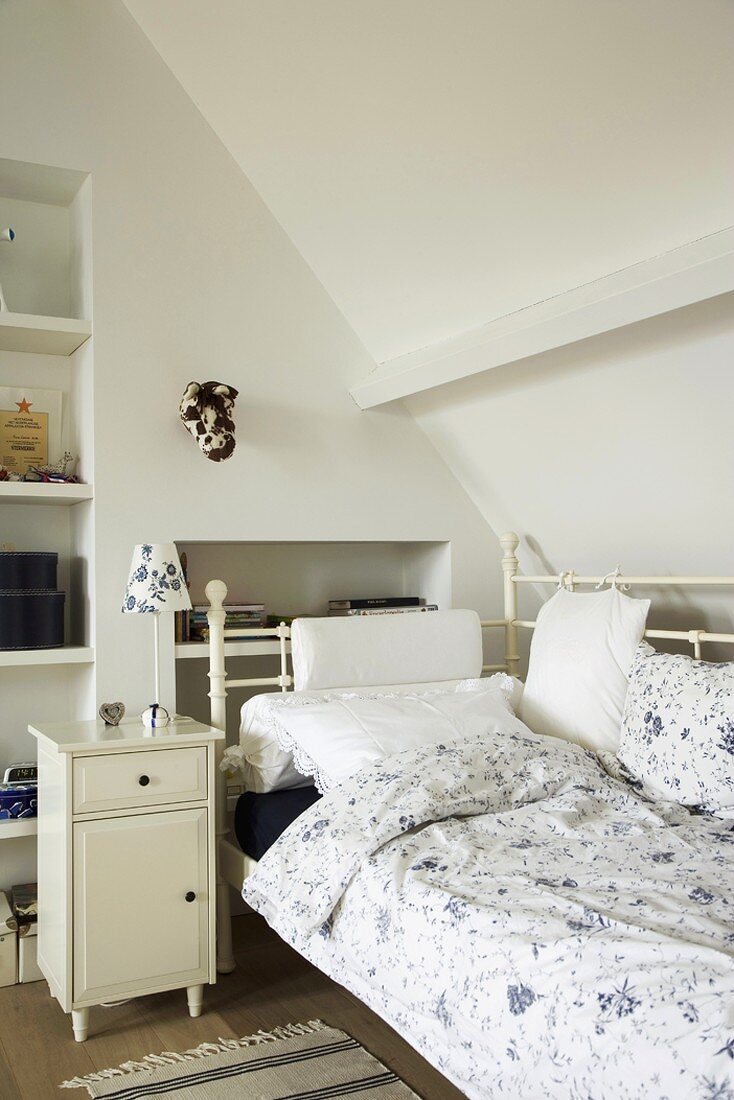 Schlafzimmer im Dachgeschoss mit schönem Tagesbett und Vintageschränkchen