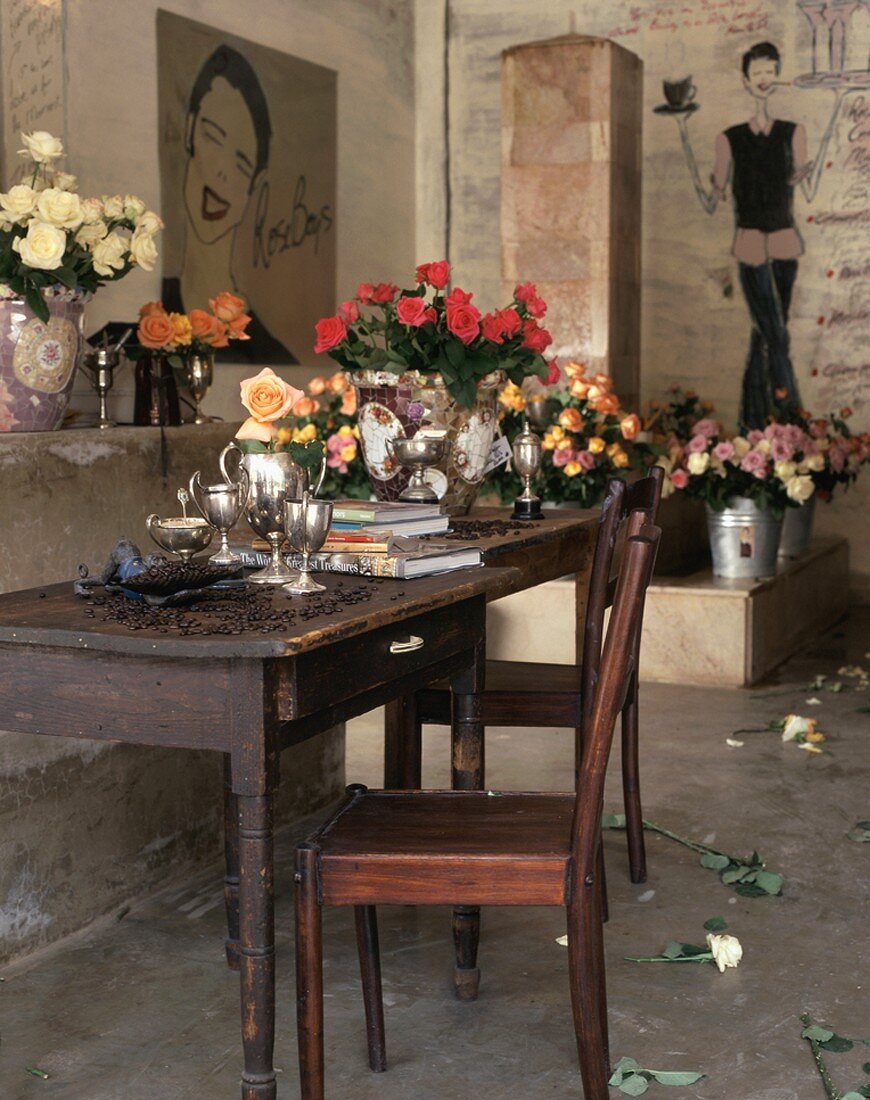 Diverse Rosensträusse und ein antiker Holztisch und -stuhl in einem Raum mit bemalten Wänden