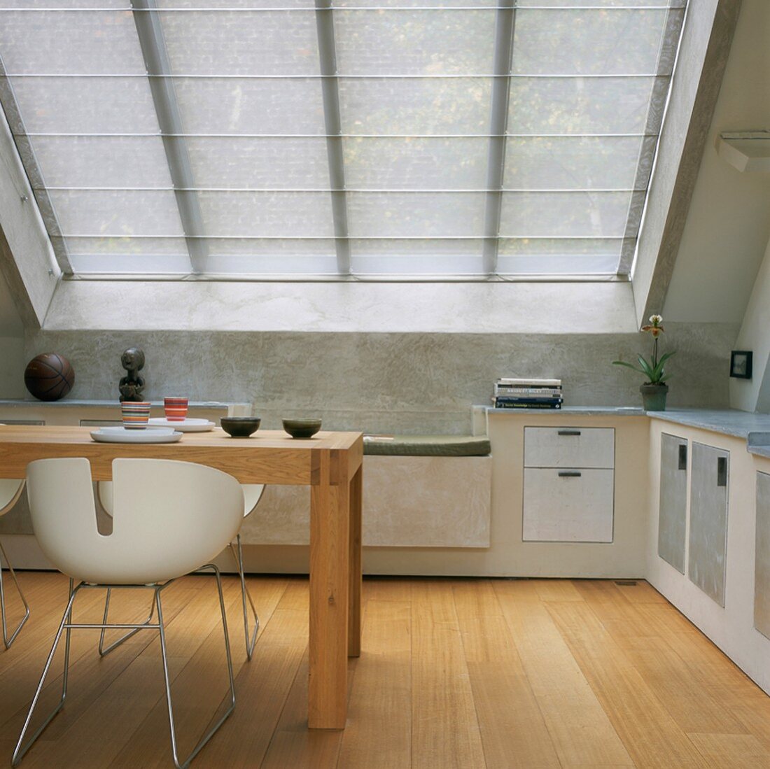 Esstisch und Designerstühle in einer Küche mit großem Dachfenster im Dachgeschoss