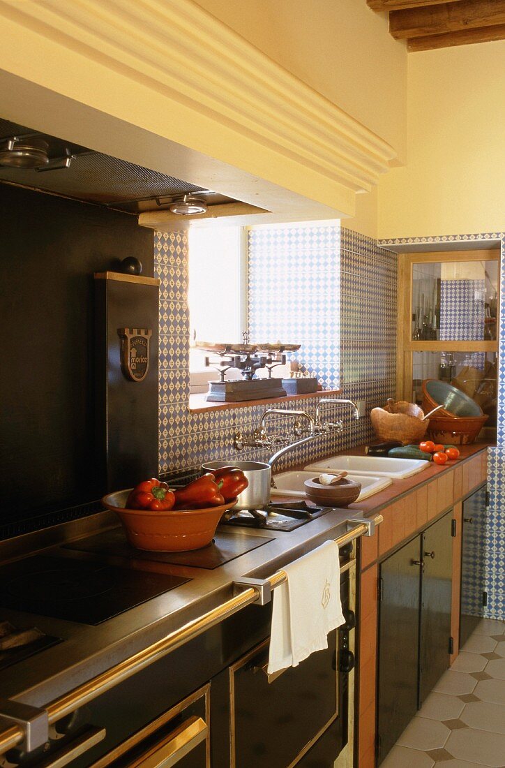 Edler Holzherd in einer eleganten Landhausküche mit blauen Wandfliesen