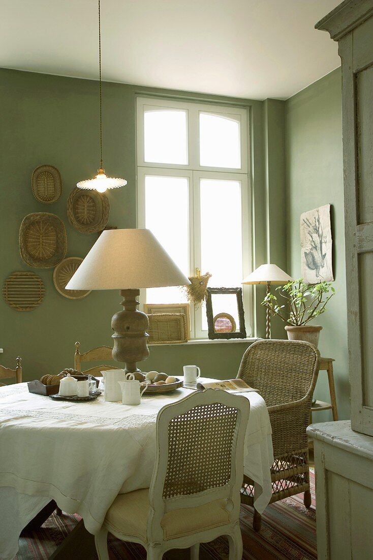 Esszimmer in Grüntönen mit rundem Kaffeetisch und Vintagedeko