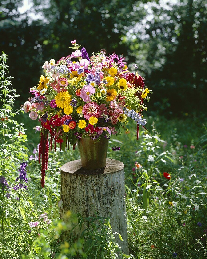 Arrangement of summer flowers on tree stump