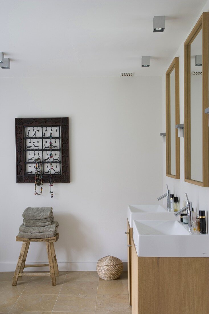 Badezimmer mit langem Waschtisch und zwei Waschschüsseln, daneben eine Schmuckgarderobe