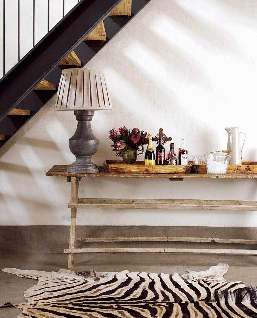 Treppennische mit rustikalem Wandtisch und einem Zebrafell als Teppich