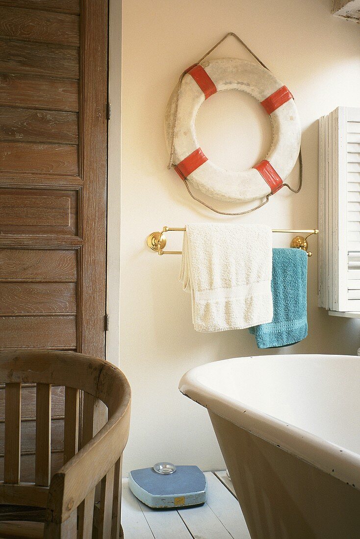 A bathroom with a decorative life belt on the wall
