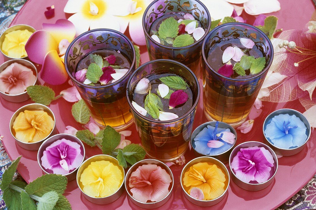 Iced tea with mint & rose petals, floral decorations outdoors