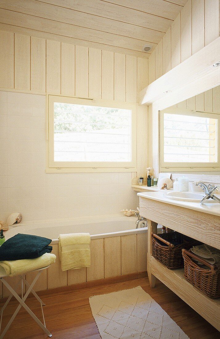 Holzverkleidetes Badezimmer mit großem Badezimmerspiegel und Aufbewahrungskörben
