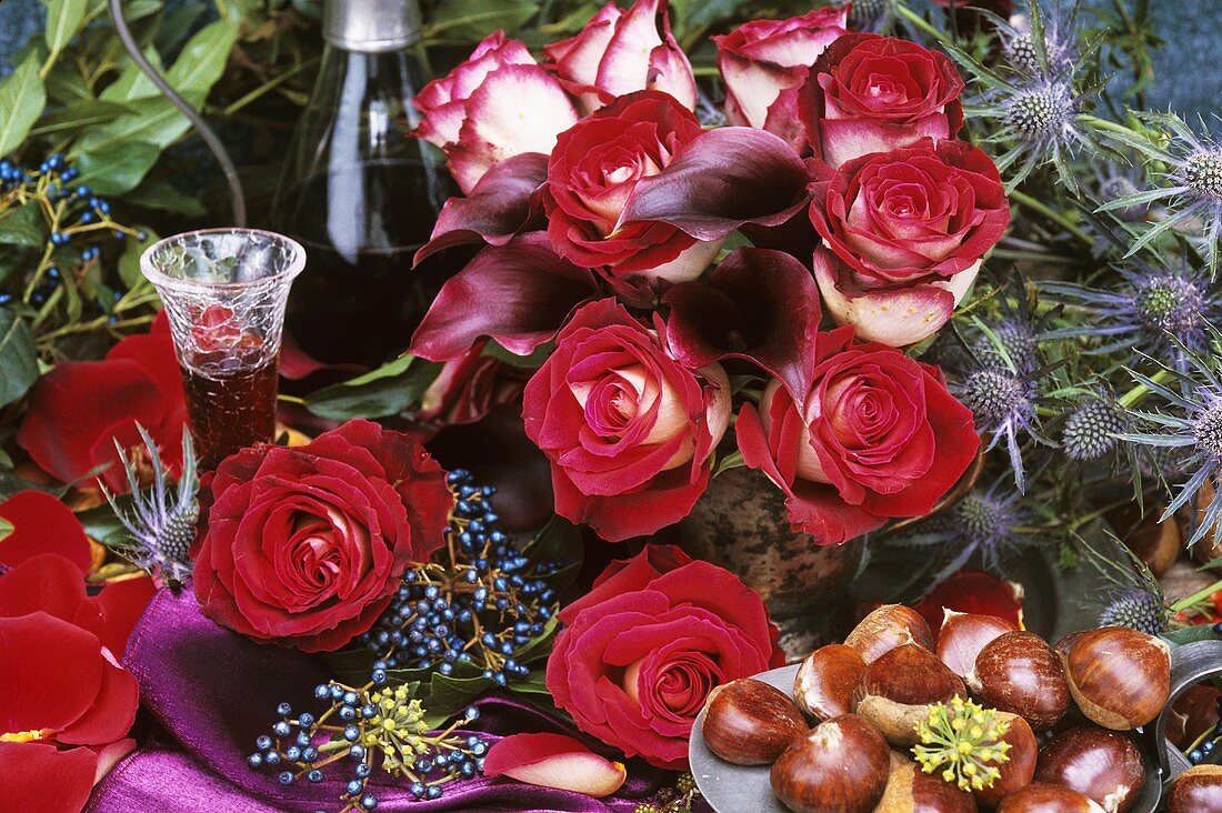 Vase of red and white roses, liqueur and sweet chestnuts