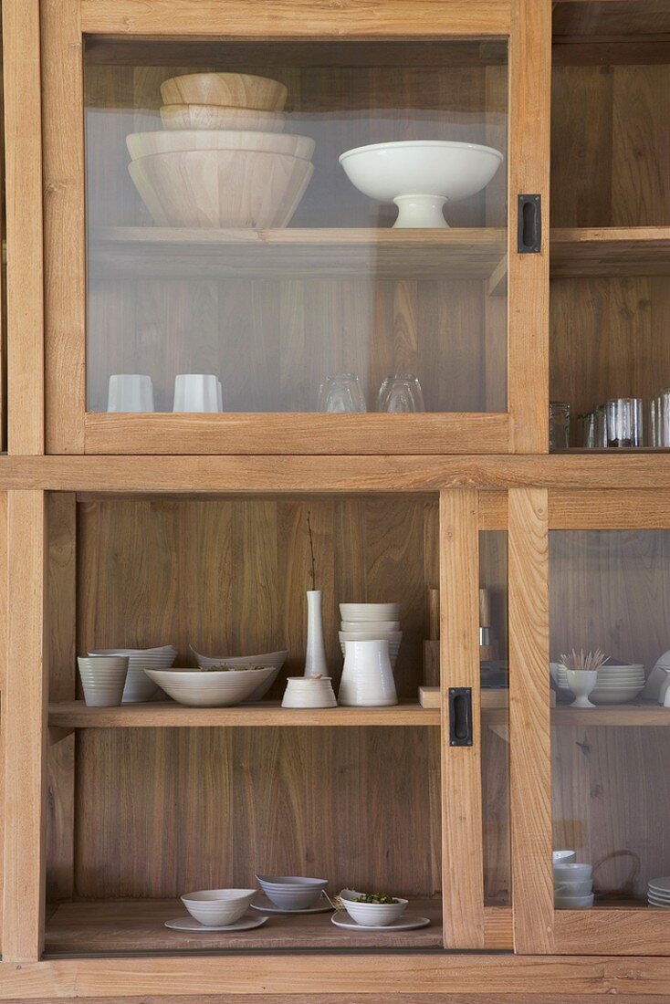 Ausschnitt eines Küchenschranks aus Holz mit Glasschiebetüren