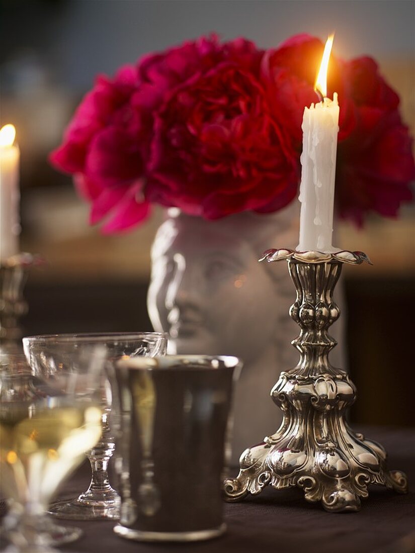 Candle in candlestick with roses and glasses