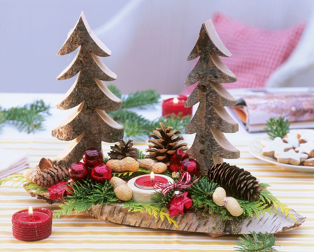 Christmas decoration: wooden fir trees, cones, baubles, candle
