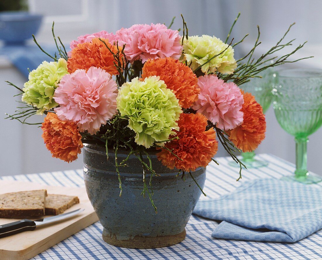 Arrangement of carnations and blueberry twigs