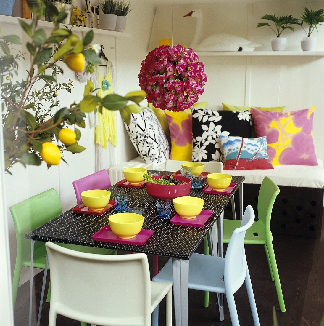 Bunt gedeckter Tisch mit Salatschüssel, Blumendeko
