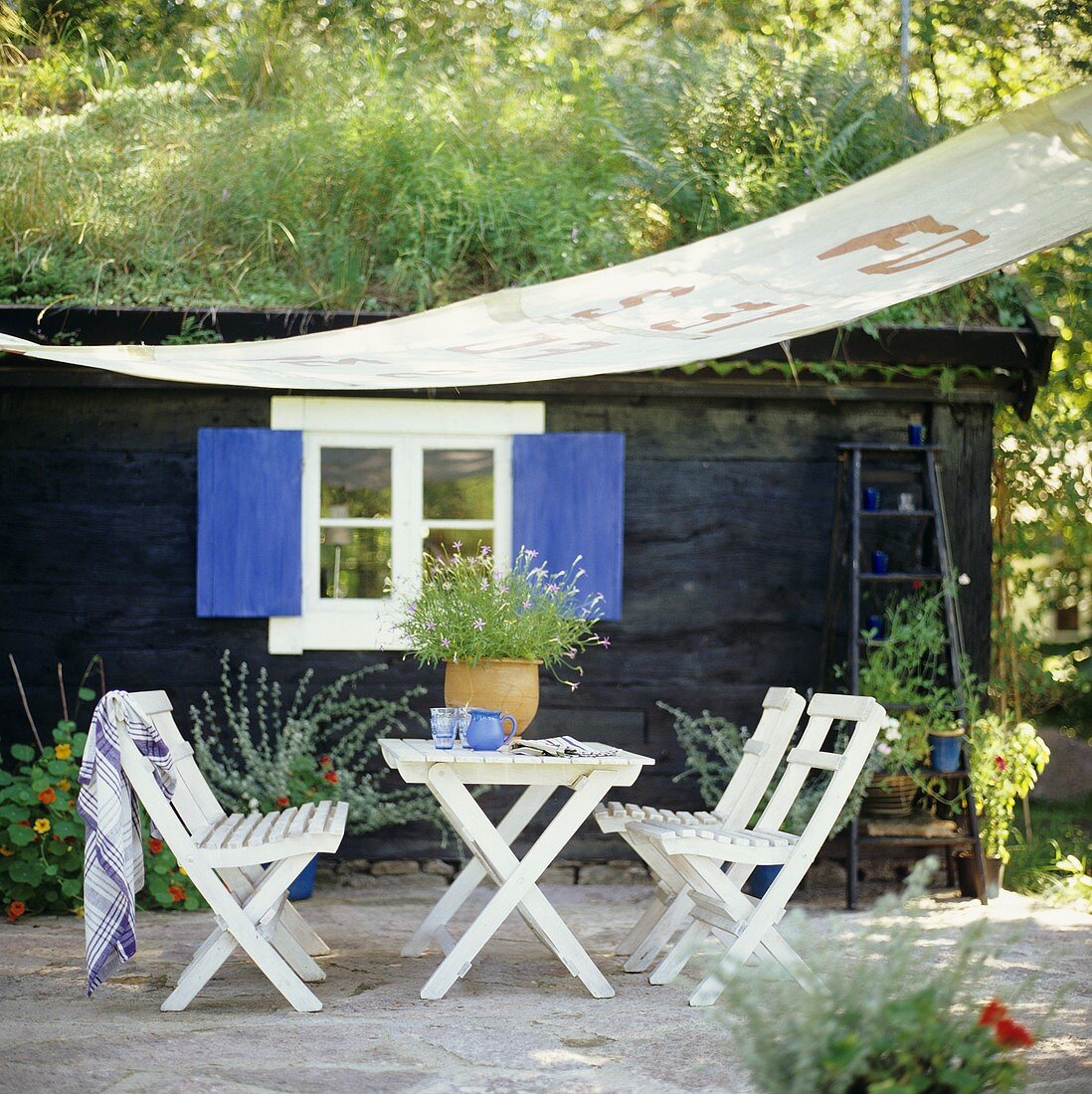 Gartentisch mit Stühlen und Sonnensegel im Freien