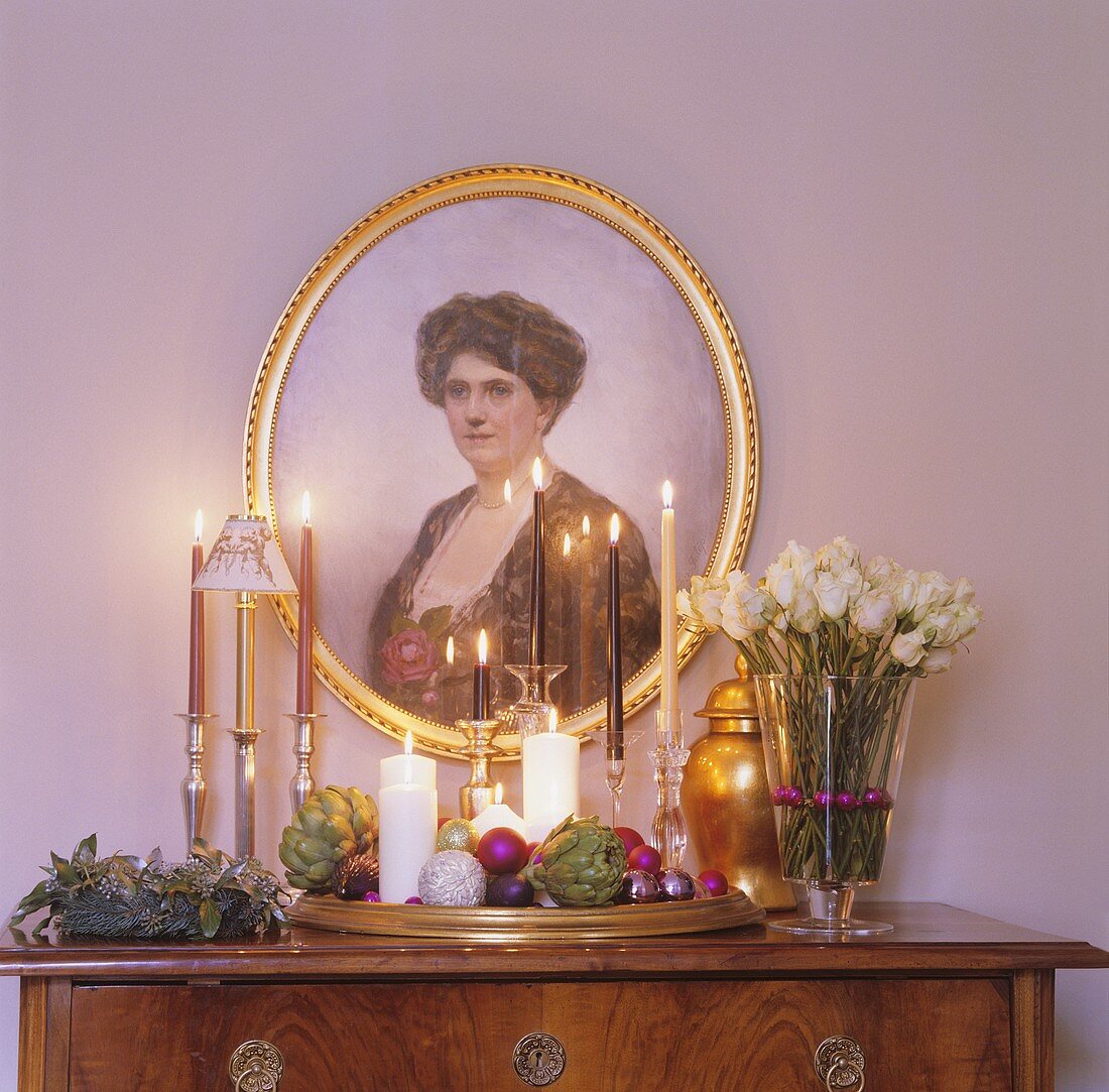Chest of drawers with Christmas decorations and portrait
