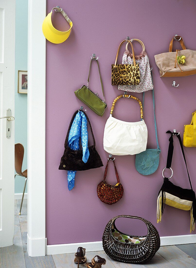 Handtaschen hängen an Haken an der Wand