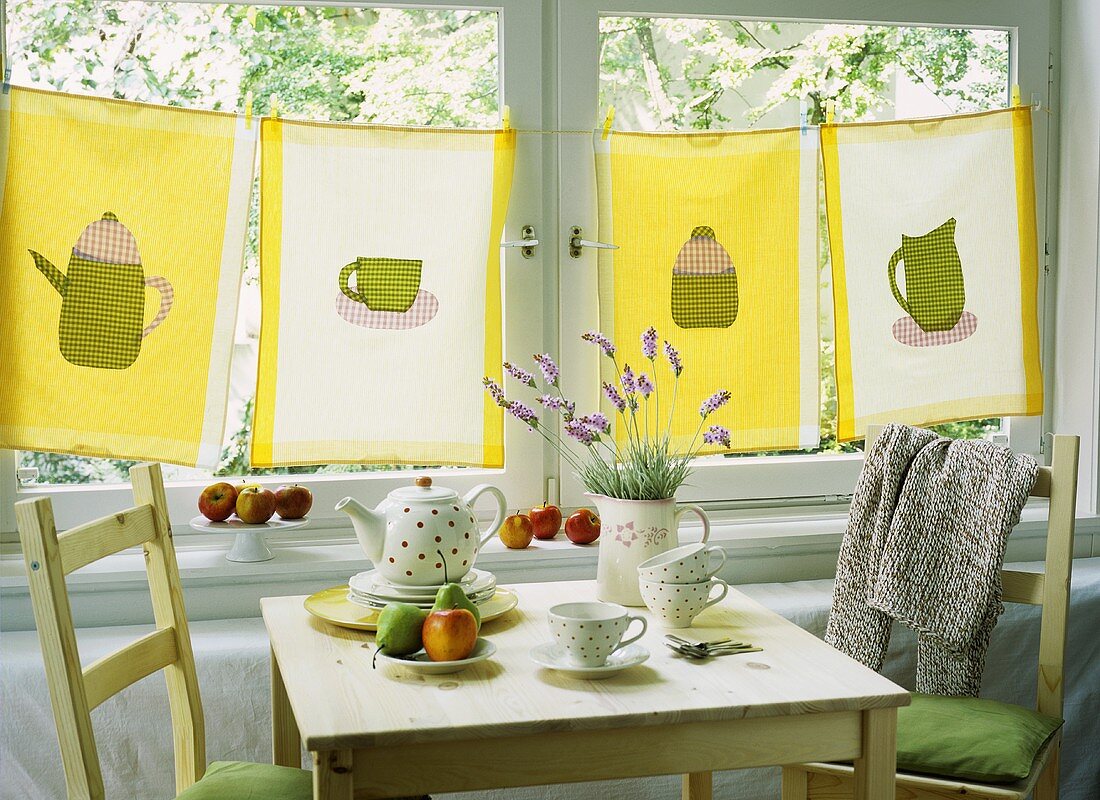 Selbstgbestickte Tücher an einer Wäscheleine vor Küchenfenster