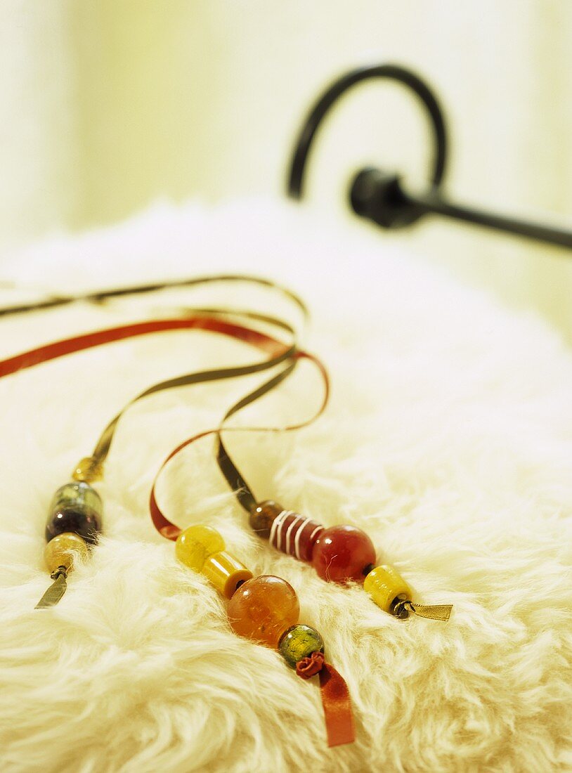 Coloured beads on satin ribbons on sheepskin