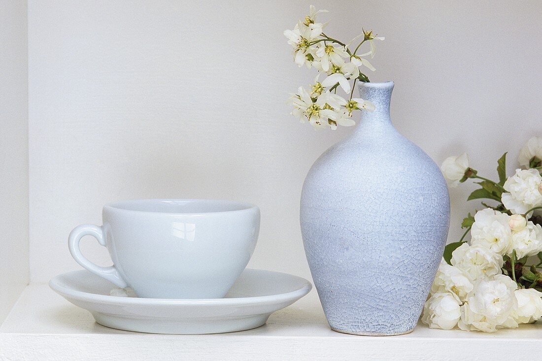 Weisses Stillleben mit Kaffeetasse, Vase und Zierkirsche