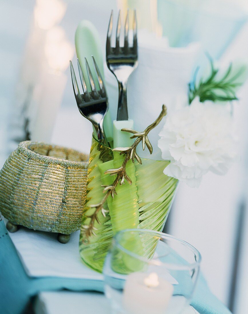 Summery table laid with cutlery and serviettes in a glass