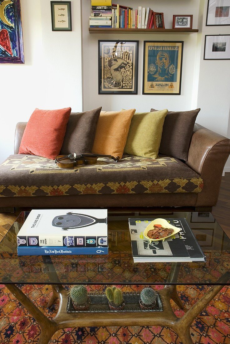 Leather sofa with colored pillows and glass top coffee table