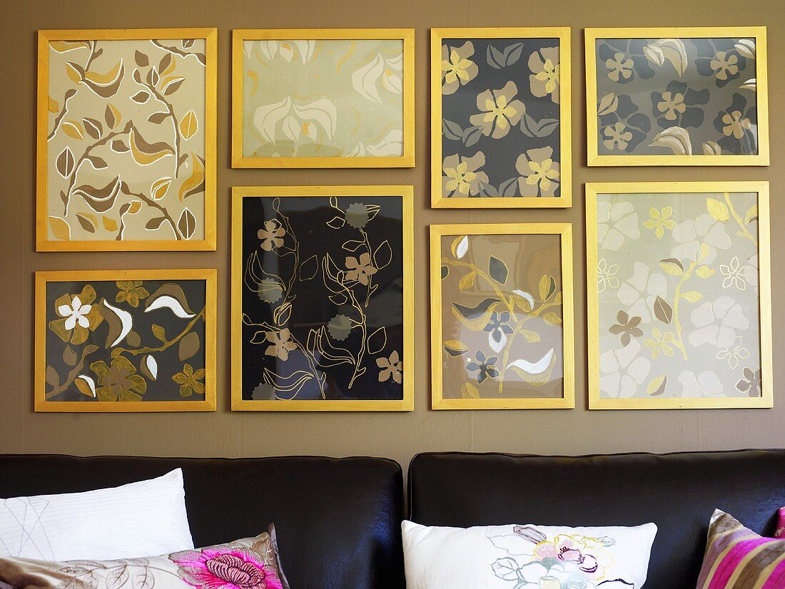 Bildergalerie mit abstrakten Blumen- & Blättermotiven an der Wand über einem Sofa