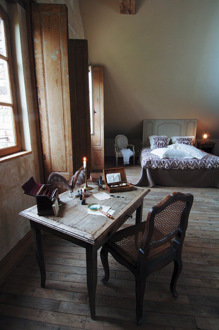 Rustikales Schlafzimmer im Schlosshotel mit Bett & Schreibtisch mit Schreibutensilien