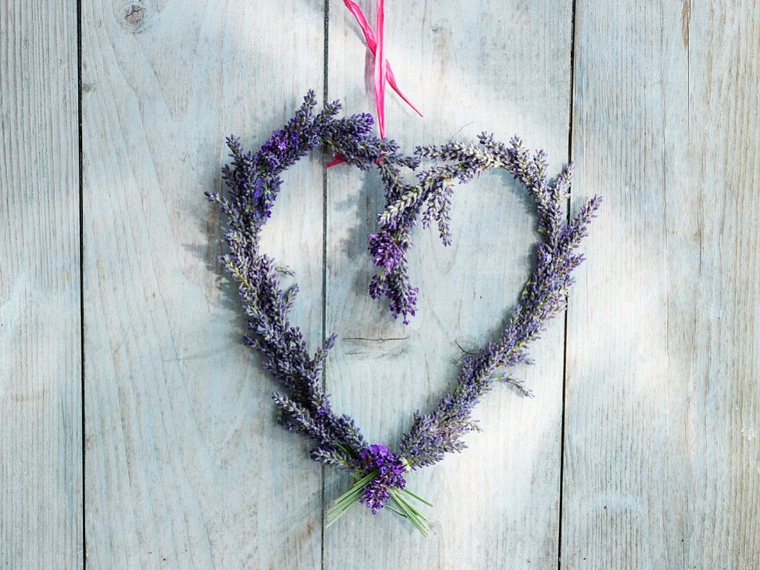 Lavendel-Herzkranz hängt an einer Holzwand