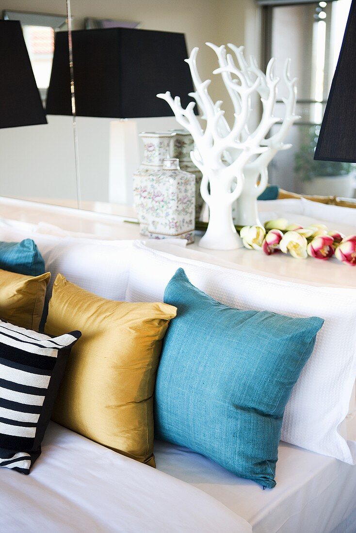 Bed with coloured cushions in bedroom