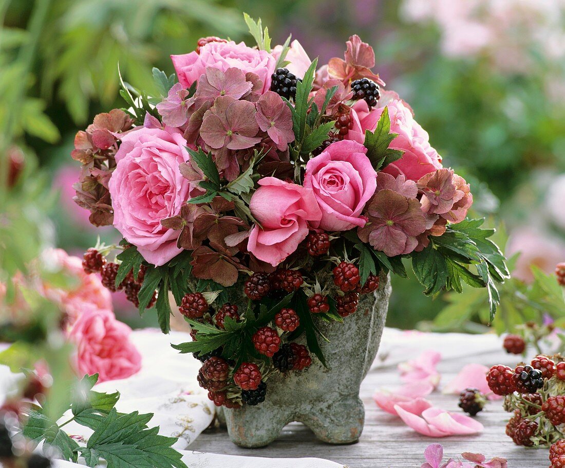 Roses, hydrangeas and blackberries in stone vase