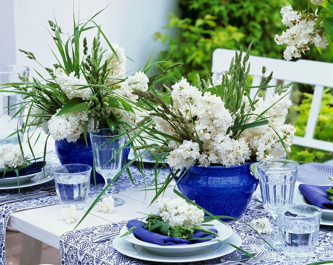Blue and white table decorations with lilac and grasses